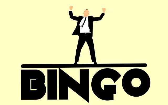 A man in a suit celebrating on top of the word 'Bingo'